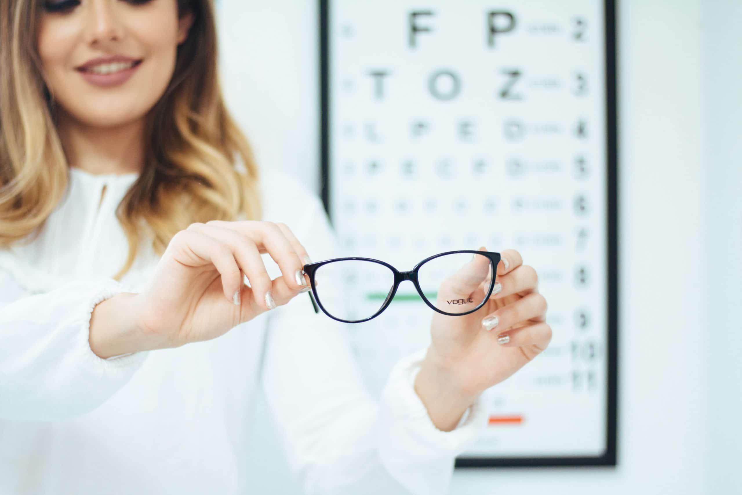 Profesional de óptica mostrando unas gafas